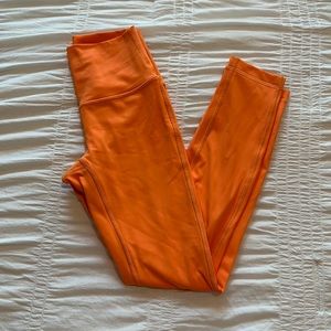 Bright orange Lululemon Wunder Under leggings